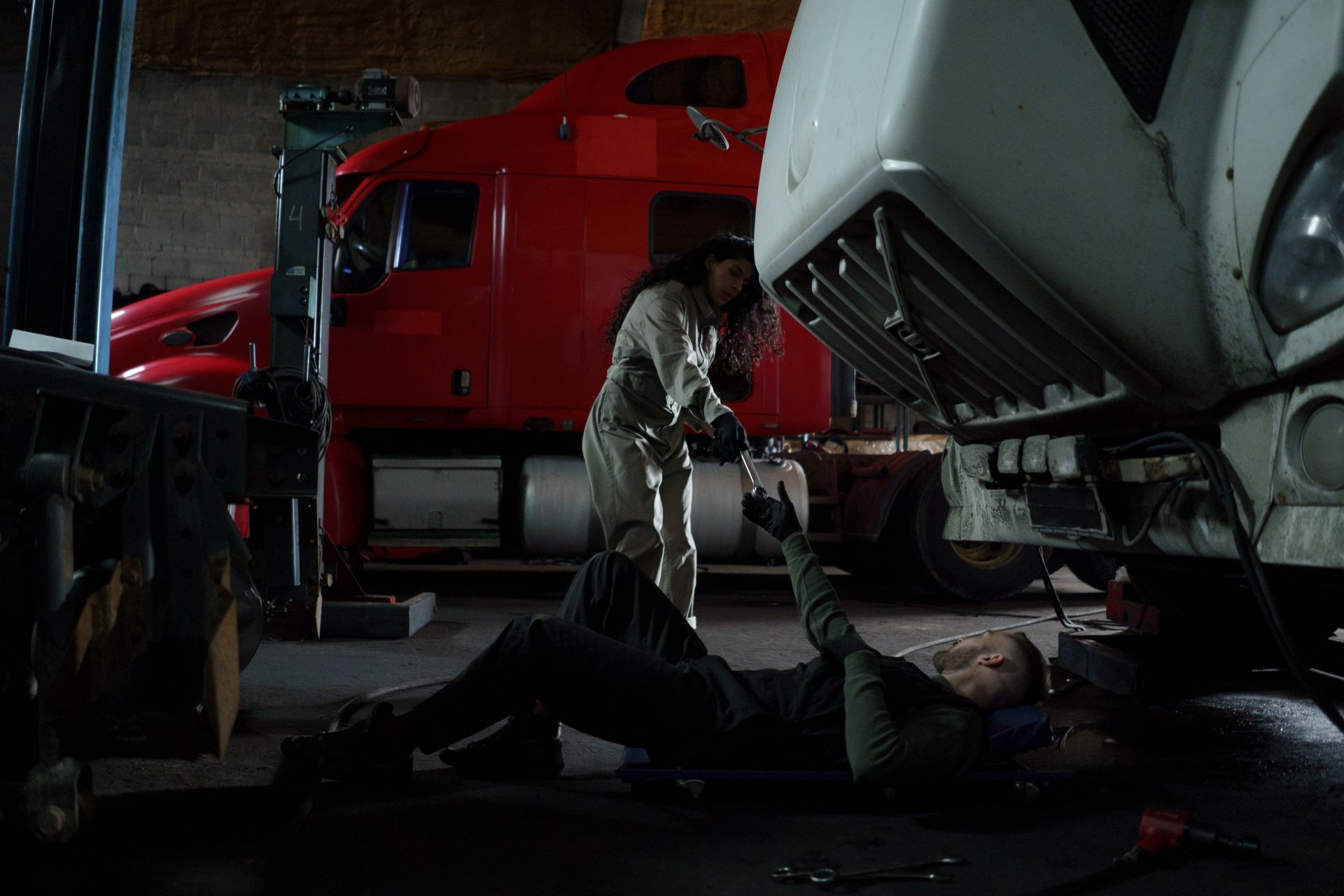 Two technicians working together on a truck in a garage