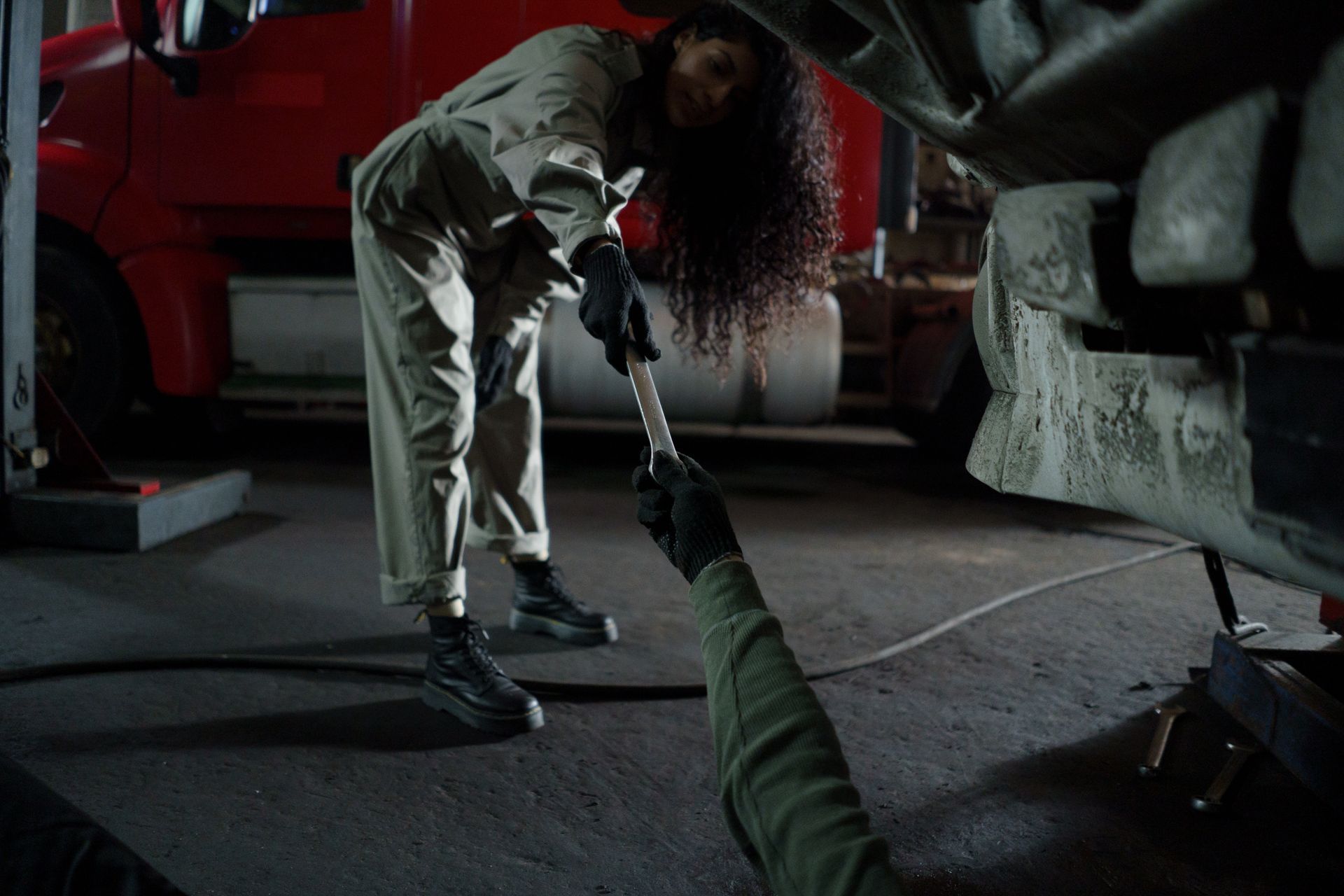 A tool being handed from one person to another across a workshop