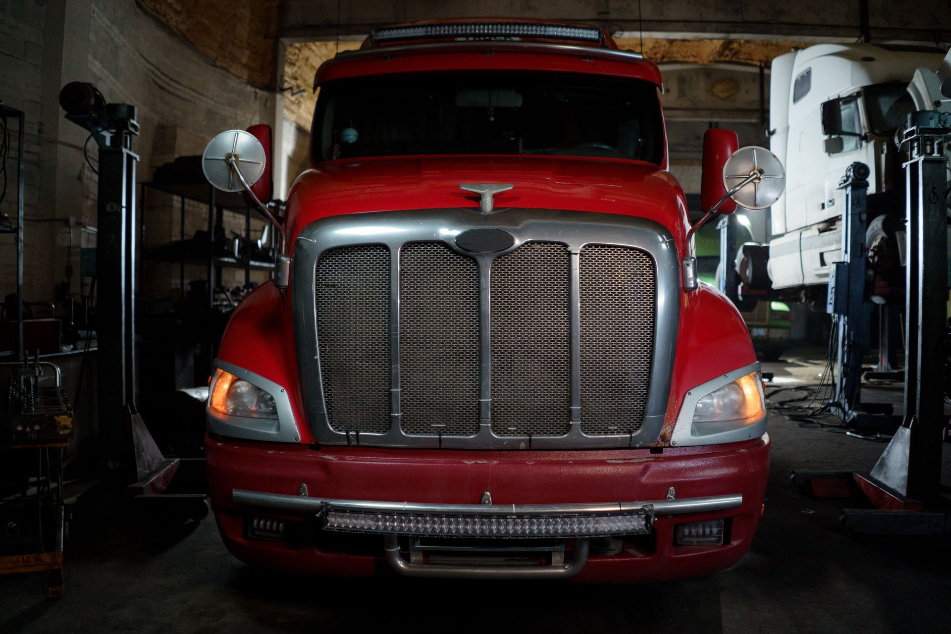 A tractor unit parked inside a workshop, seen head-on