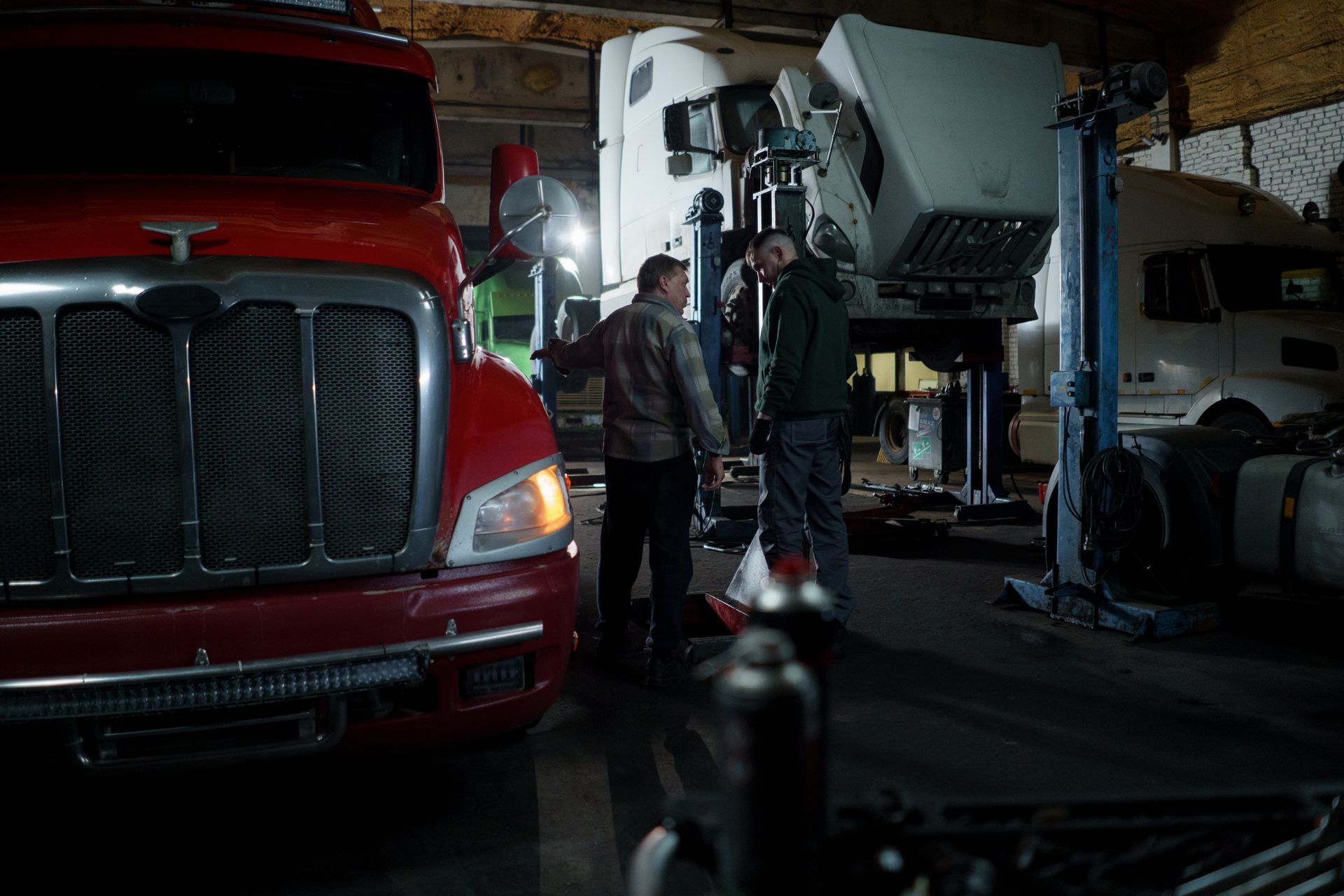 Two technicians going over a truck in a service bay