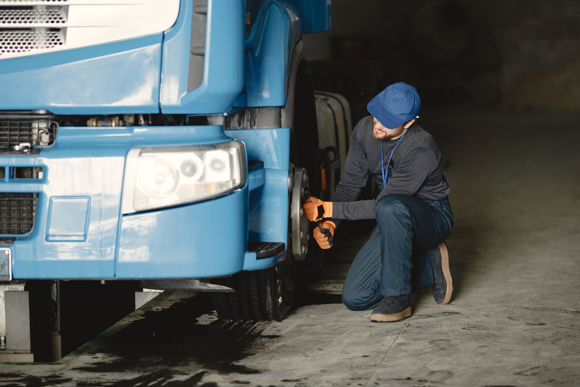 A technician working on the wheel and tire of a heavy truck