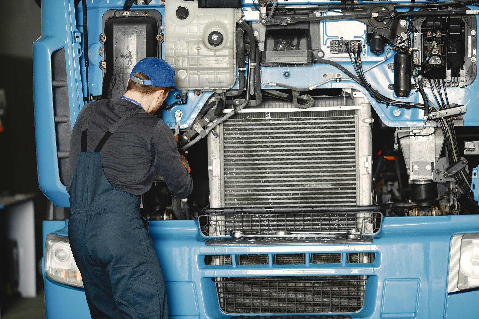 A technician working on a heavy truck engine in a workshop