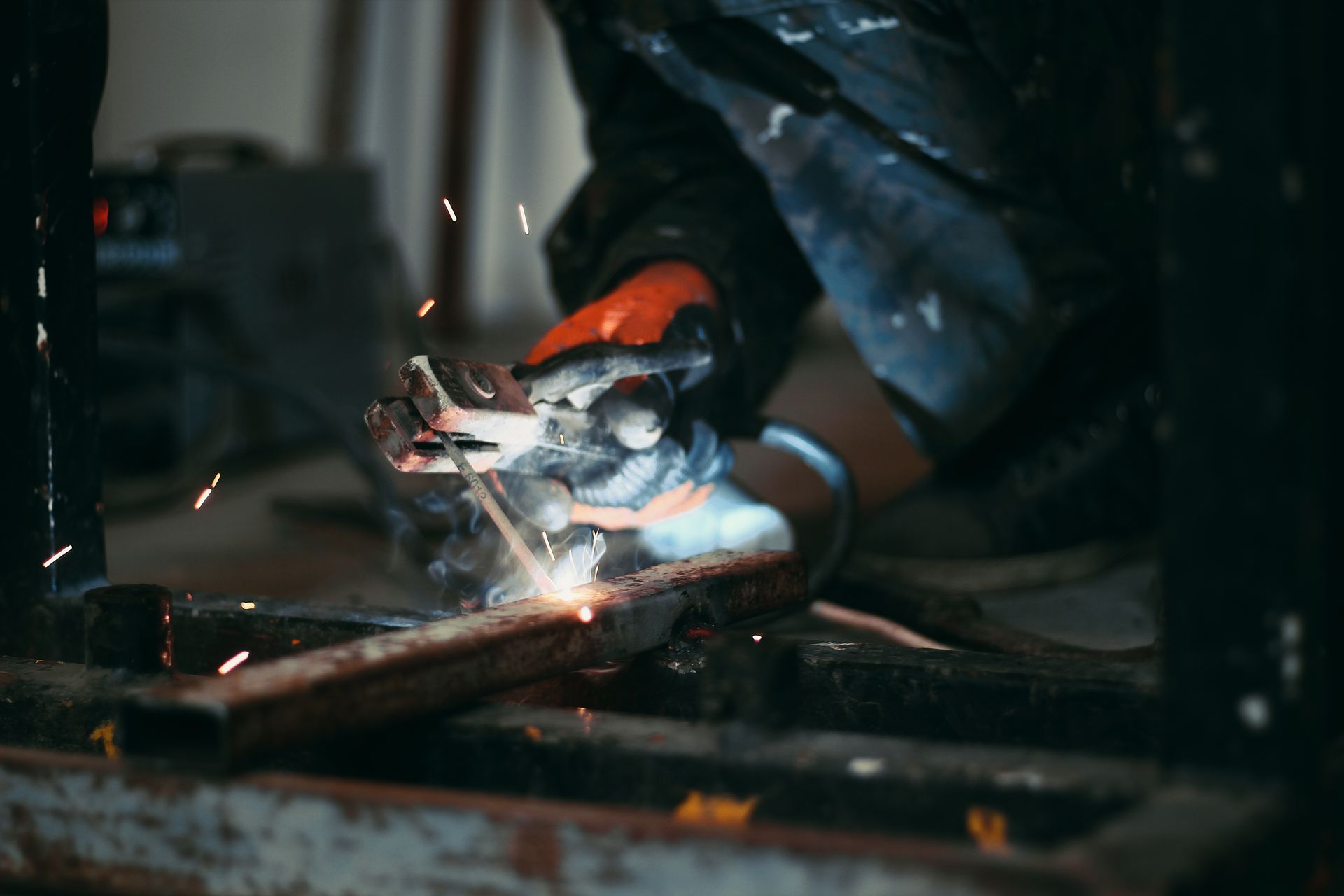A welder striking an arc, sparks coming off the workpiece